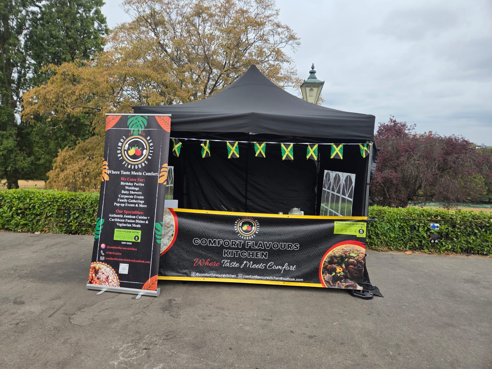Comfort Flavours Kitchen market stall at the Horniman with branded banners and Jamaican flag bunting